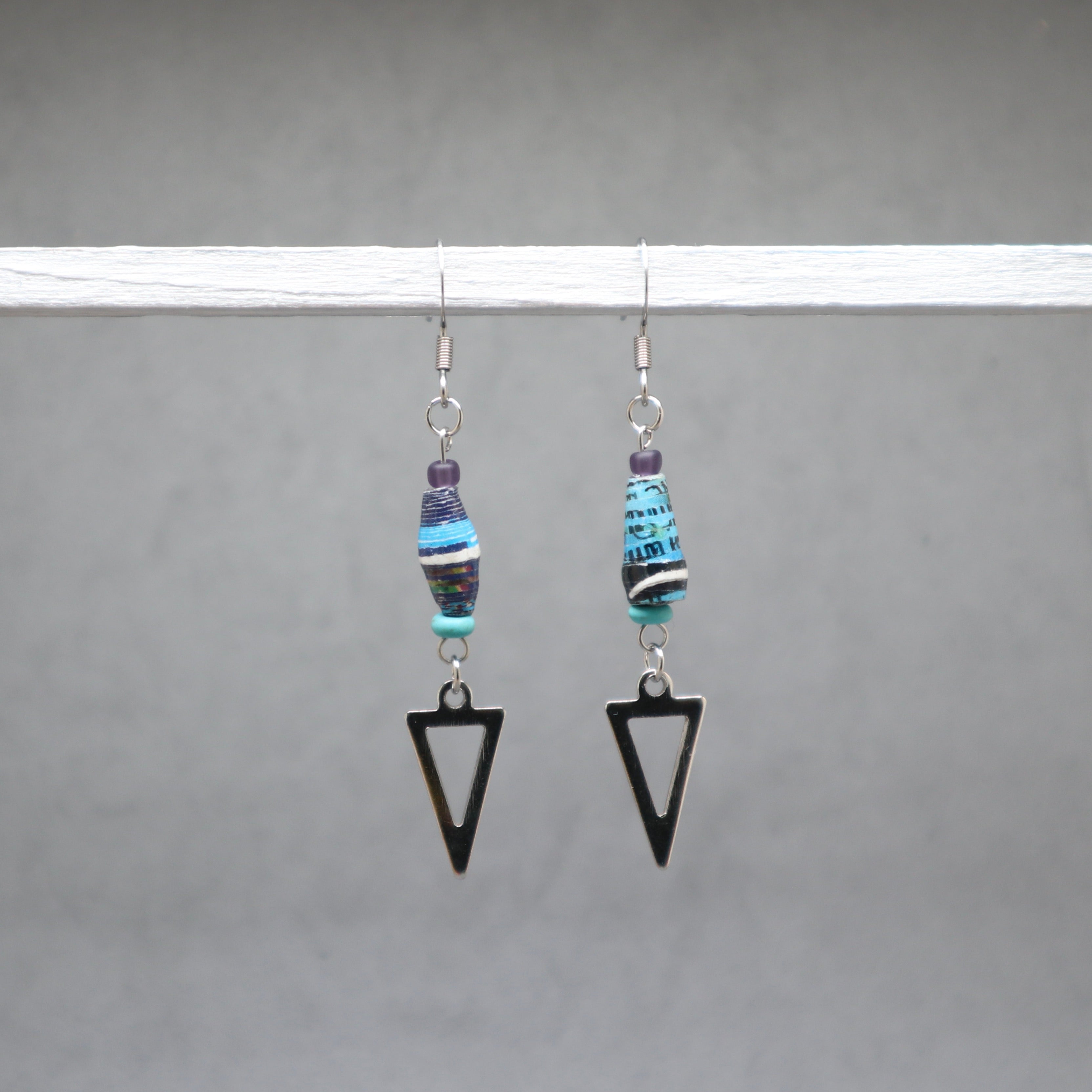 Pair of earrings with beaded elements and black triangle shapes on a gray background, paper beads from Ouganda with stainless steel