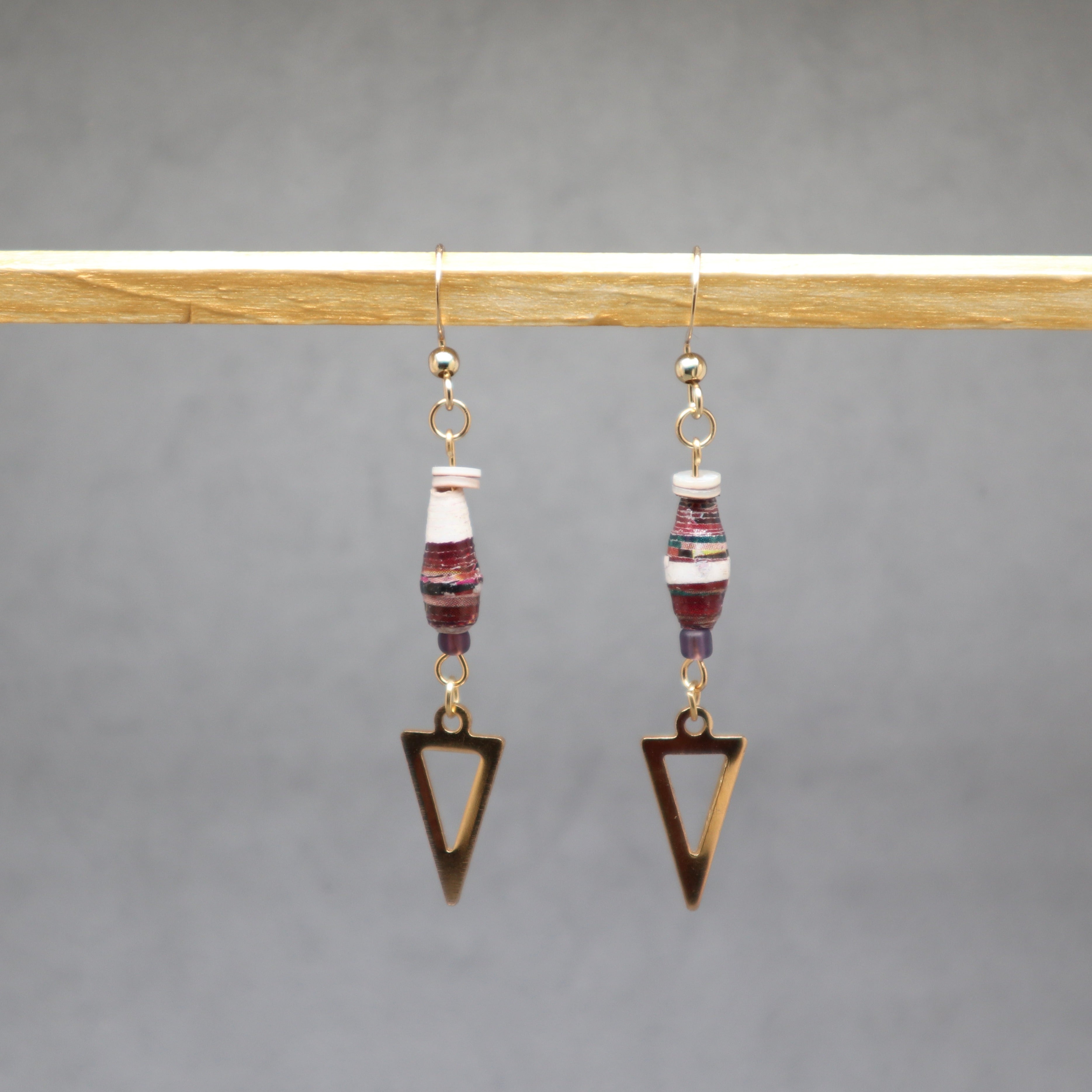 Pair of earrings with triangle-shaped pendants on a gray background, paper Uganda, stainless steel, shell