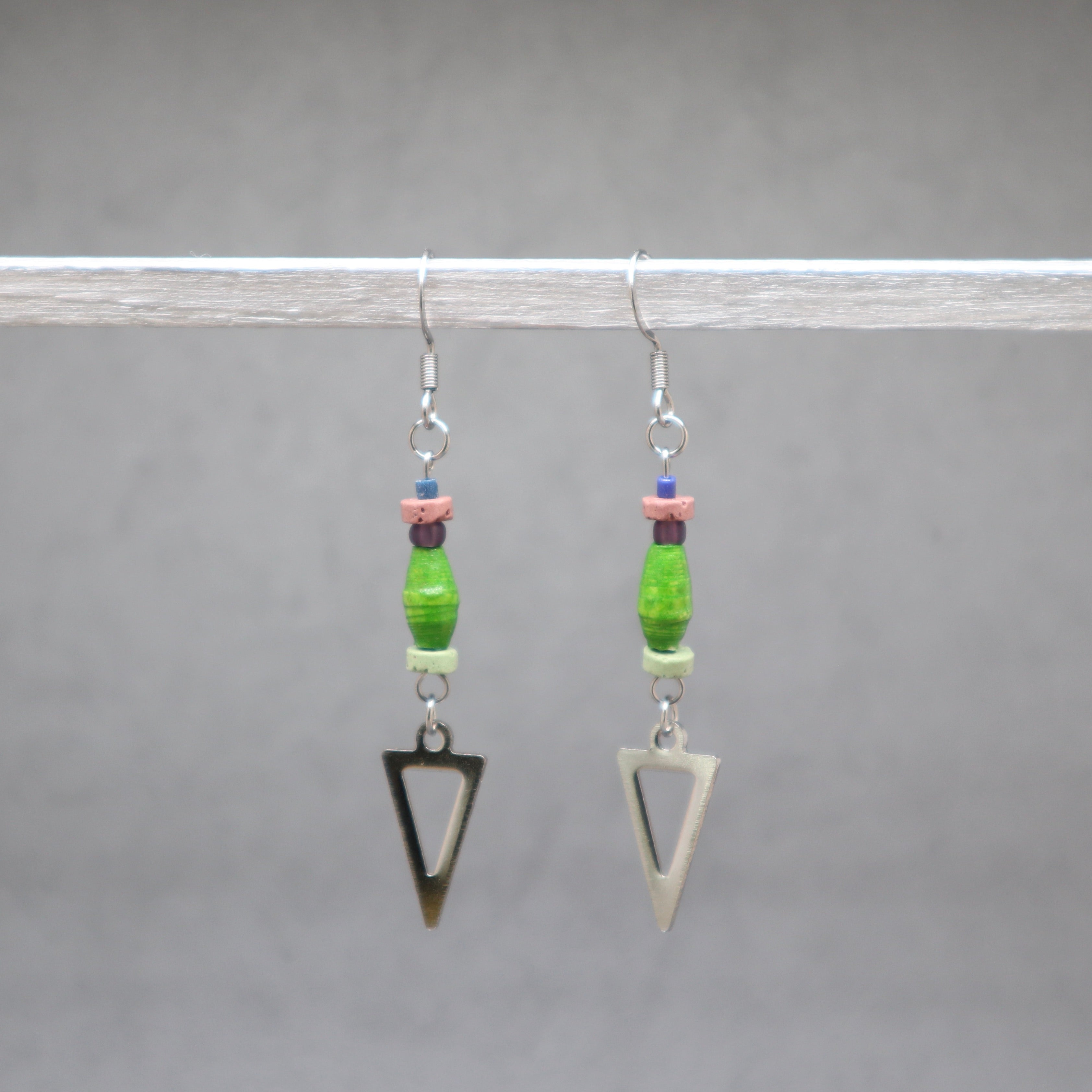 Pair of earrings with green beads and triangle charms on a gray background, paper bers from Ouganda with silver stainless steel