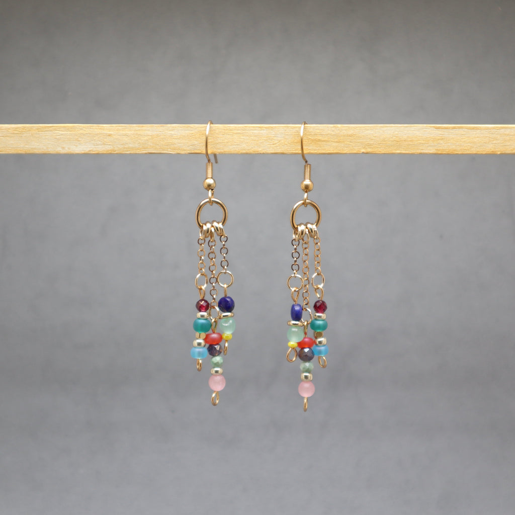 Multicolored beaded earrings on a gray background, stainless steel gold