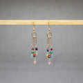 Multicolored beaded earrings on a gray background, stainless steel gold