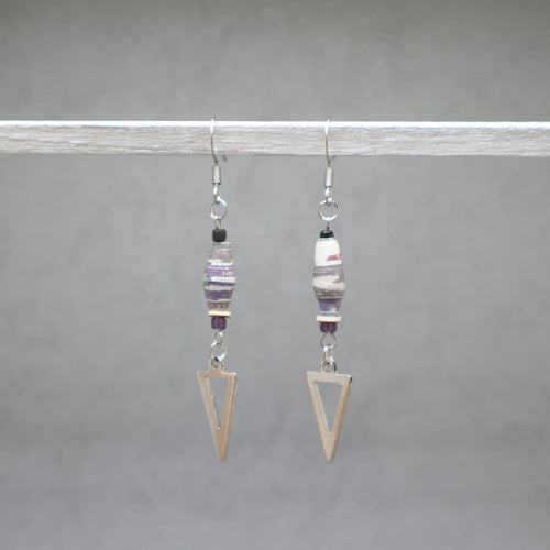 Pair of earrings with geometric designs on a gray background. Paper beads violet with silver arrows