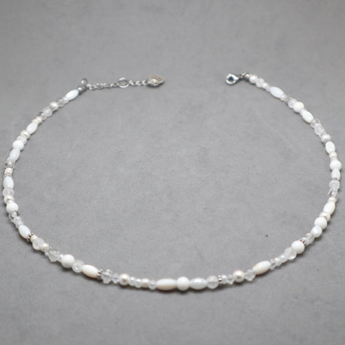 Necklace with white beads on a gray background, white and silver necklace for women