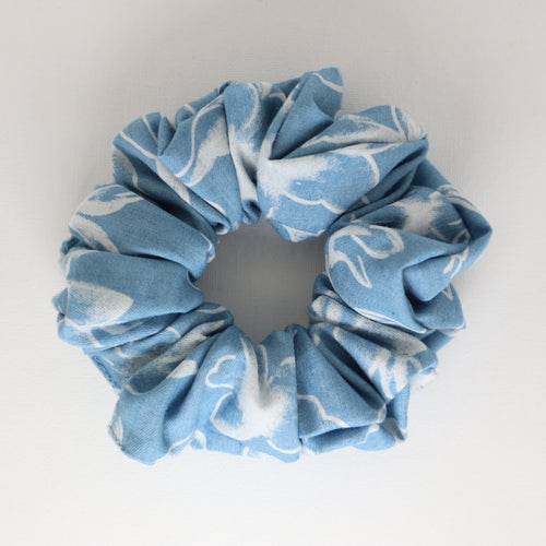 Blue and white patterned scrunchie on a light gray background