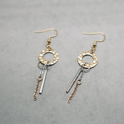 Pair of gold and silver earrings on a gray background