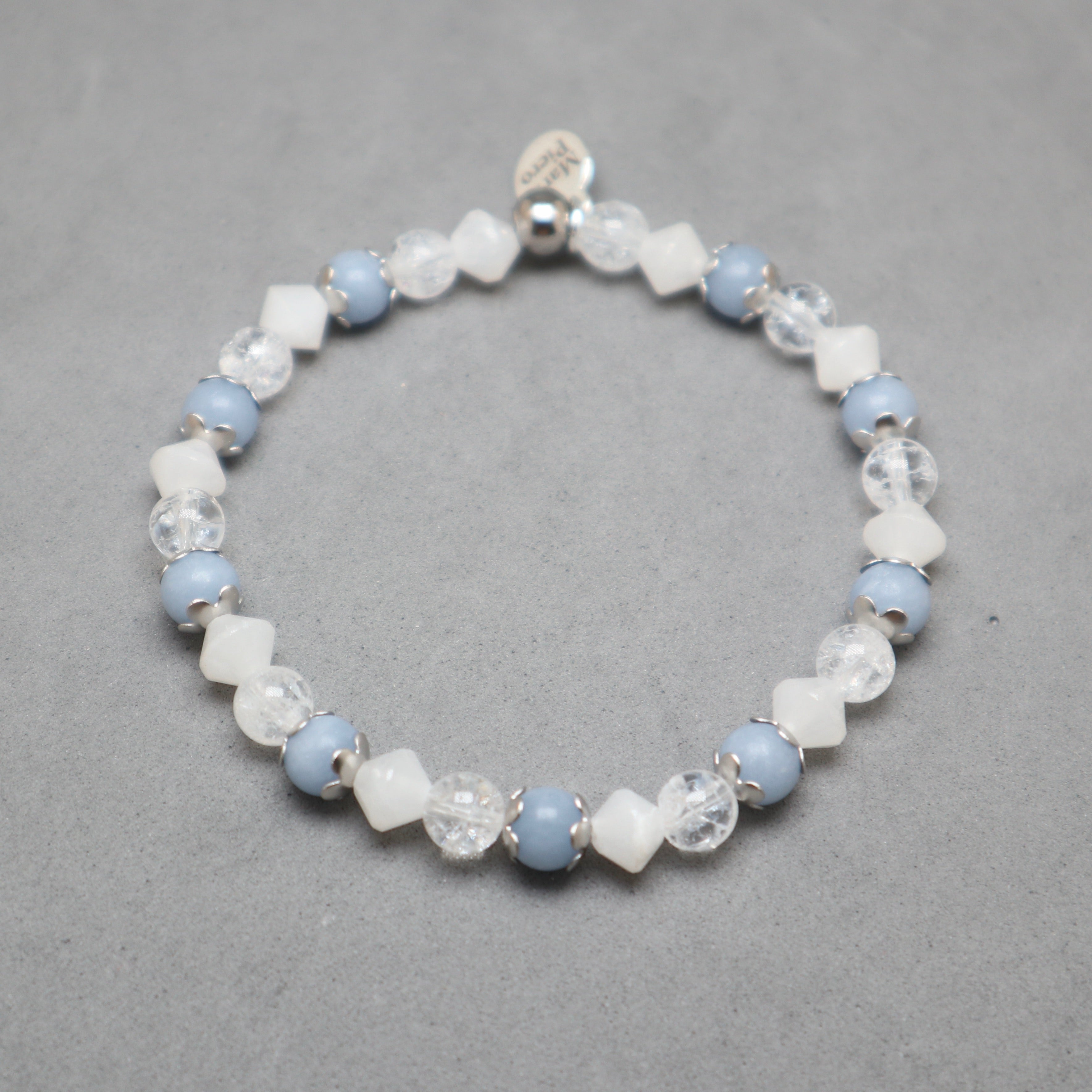 Beaded bracelet with blue and white beads on a gray background