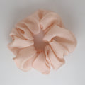 Pink coral scrunchie on a light gray background