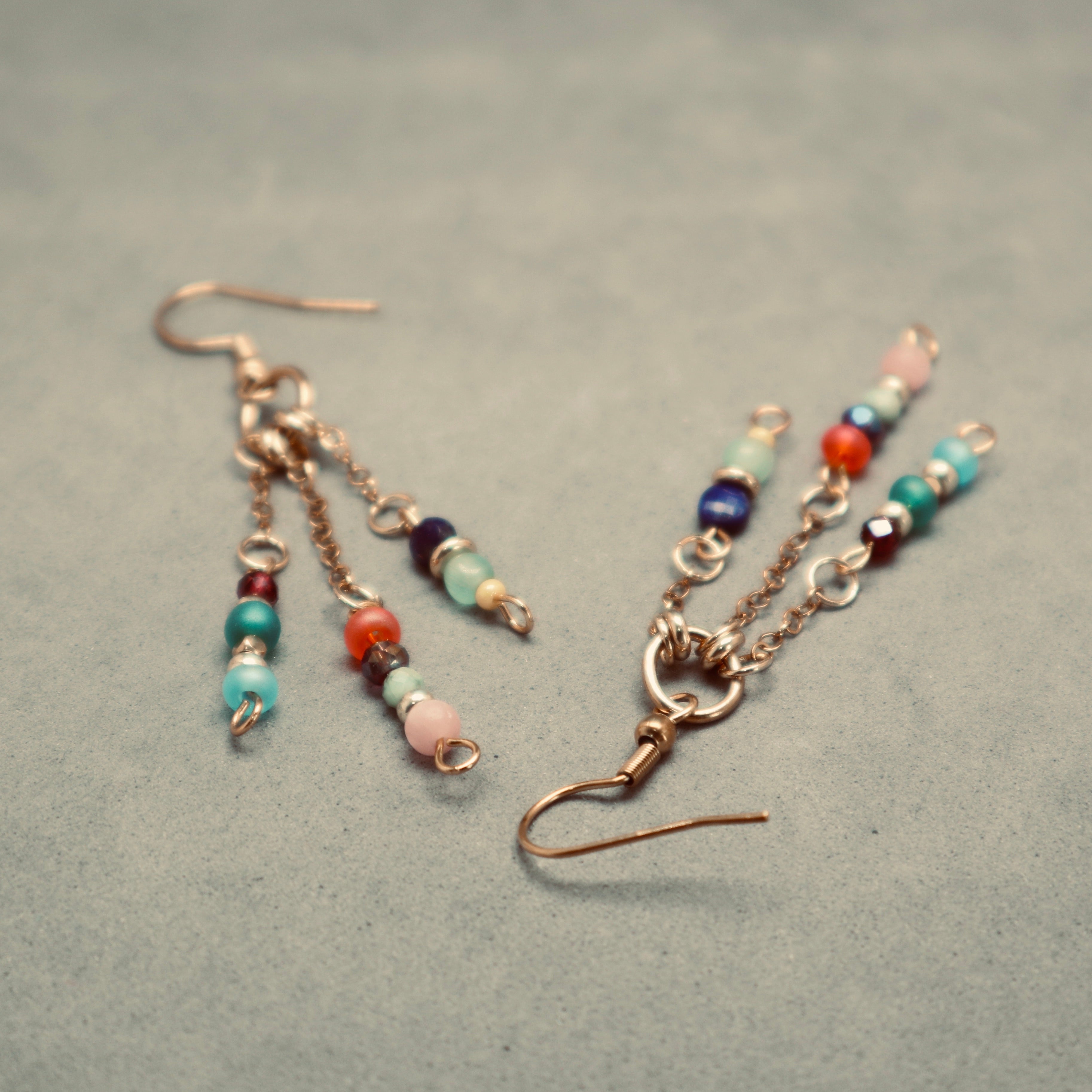 Beaded earrings on a textured gray surface