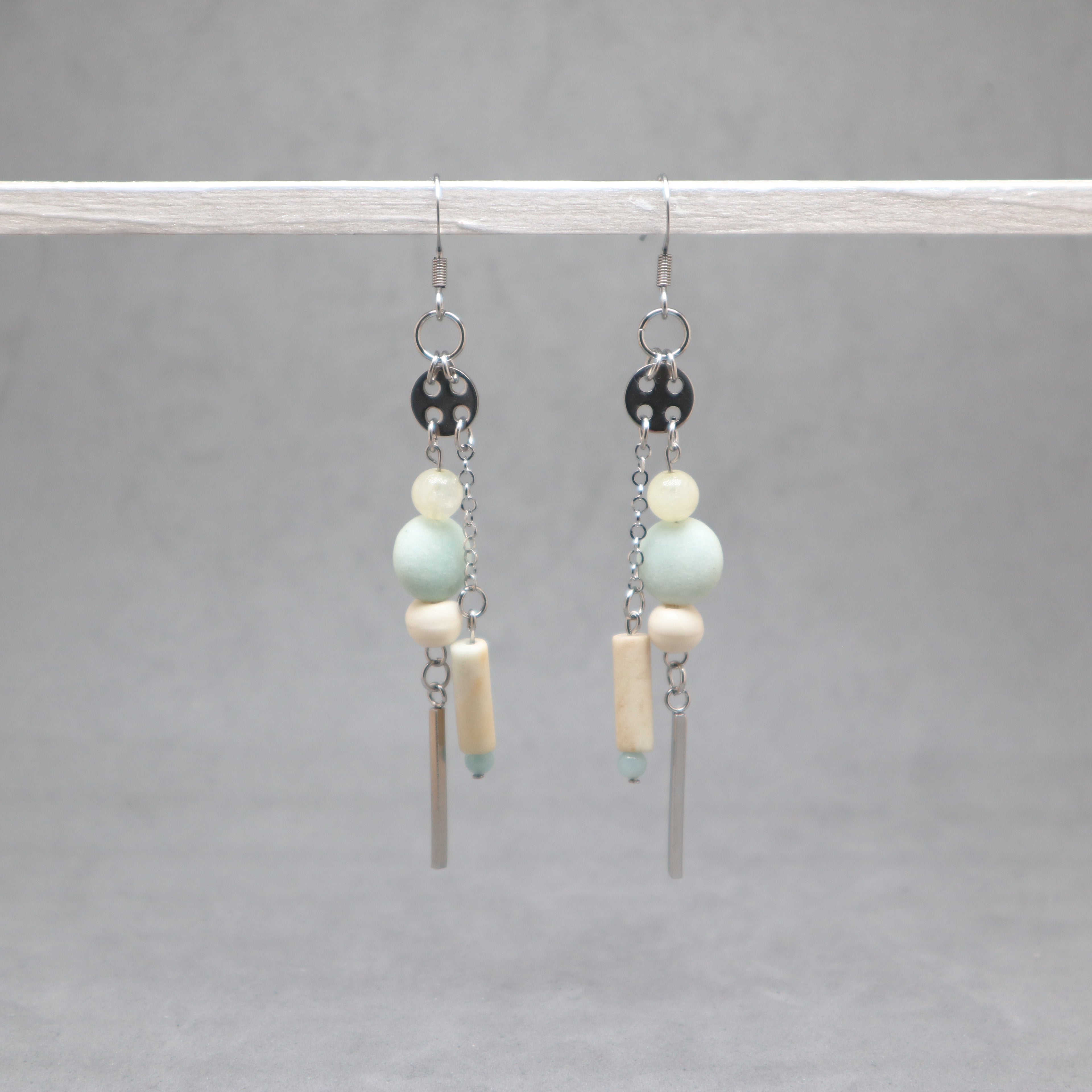 Pair of earrings with beads and bars on a gray background, amazonite, citrin