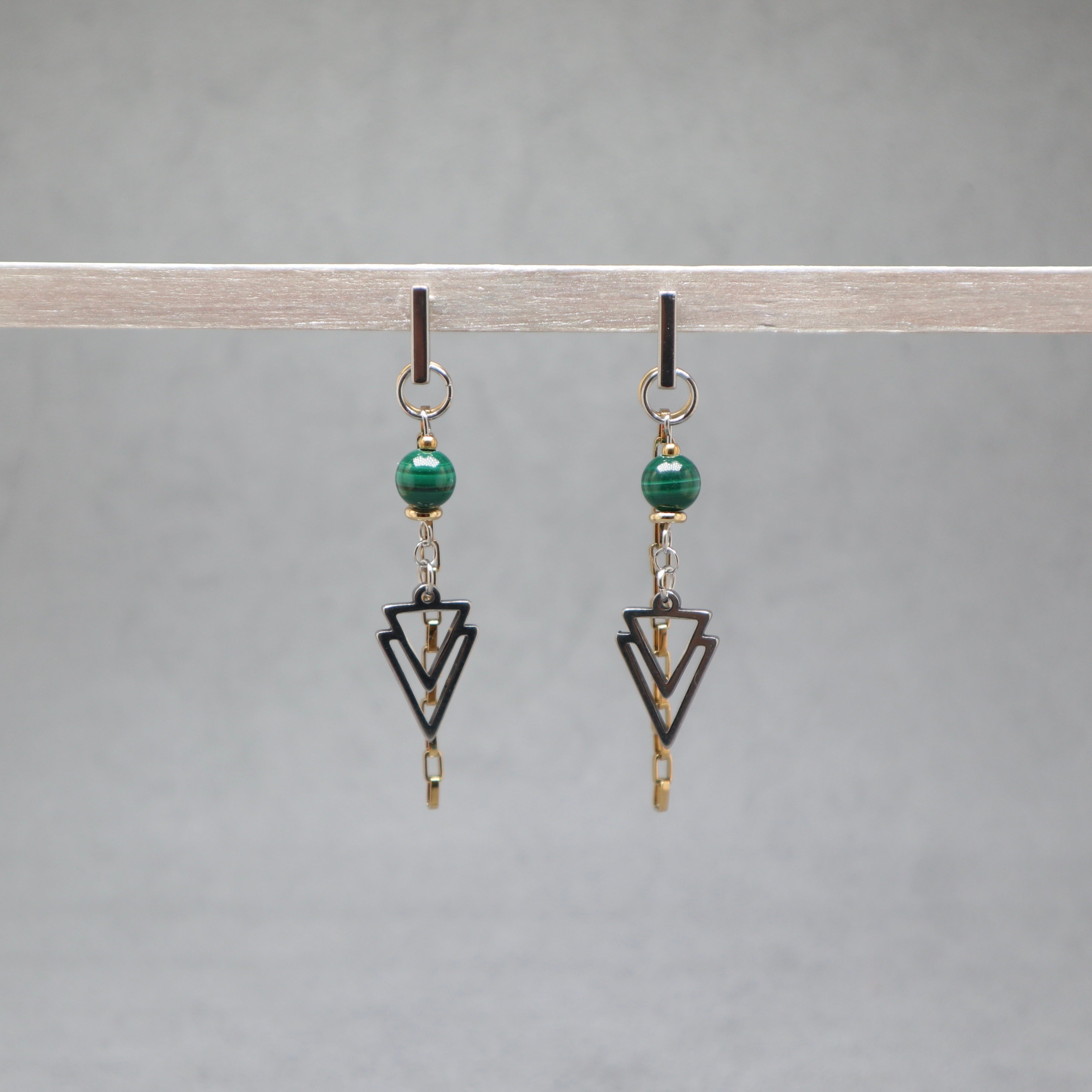 Pair of earrings with green beads and black geometric shapes on a gray background, malachite, stainless steel silver and gold