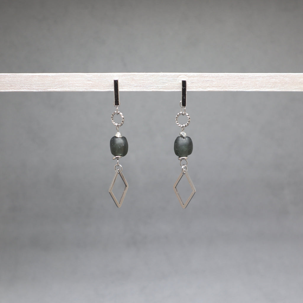 Pair of earrings with geometric designs on a gray background
