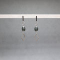 Pair of earrings with geometric designs on a gray background