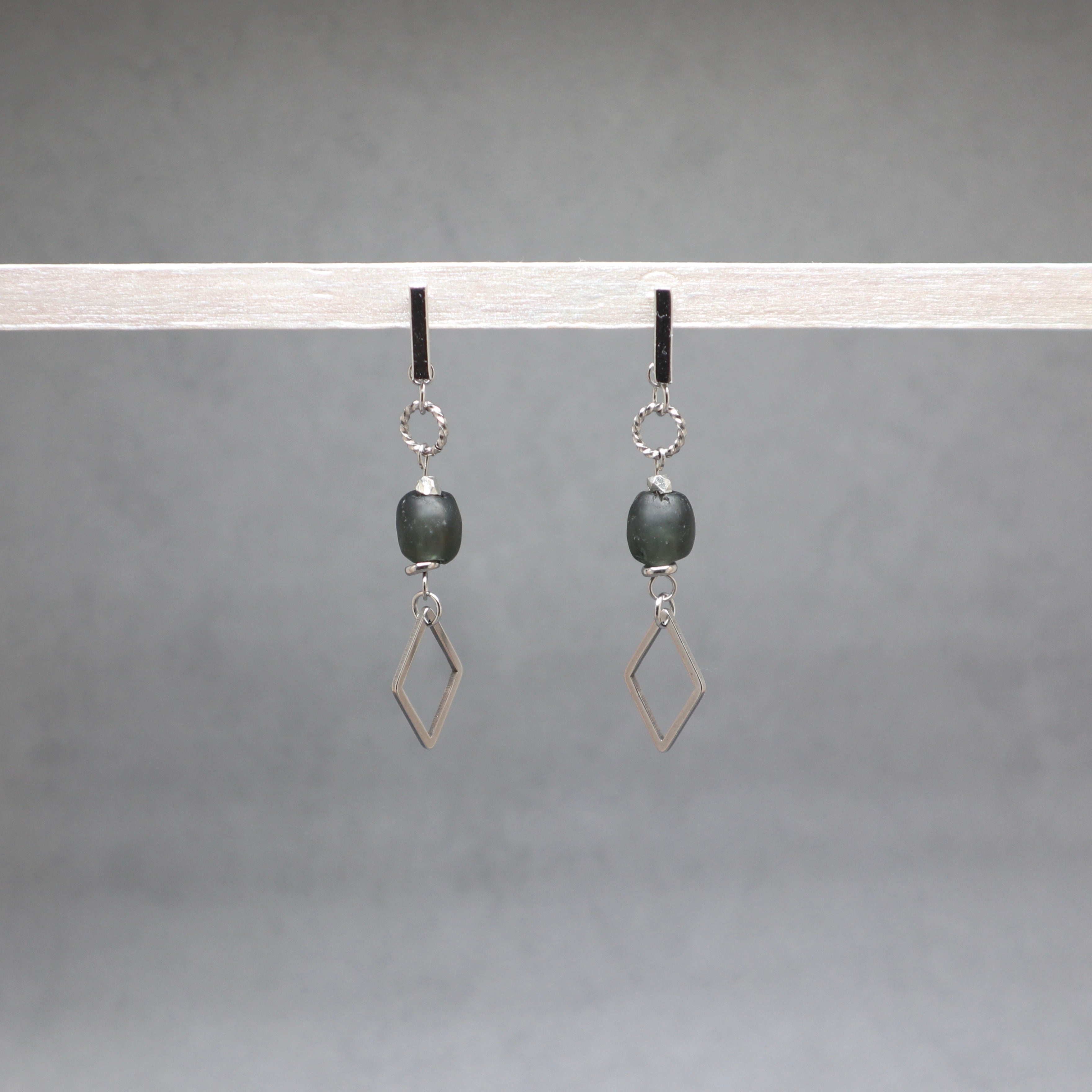 Pair of earrings with geometric designs on a gray background
