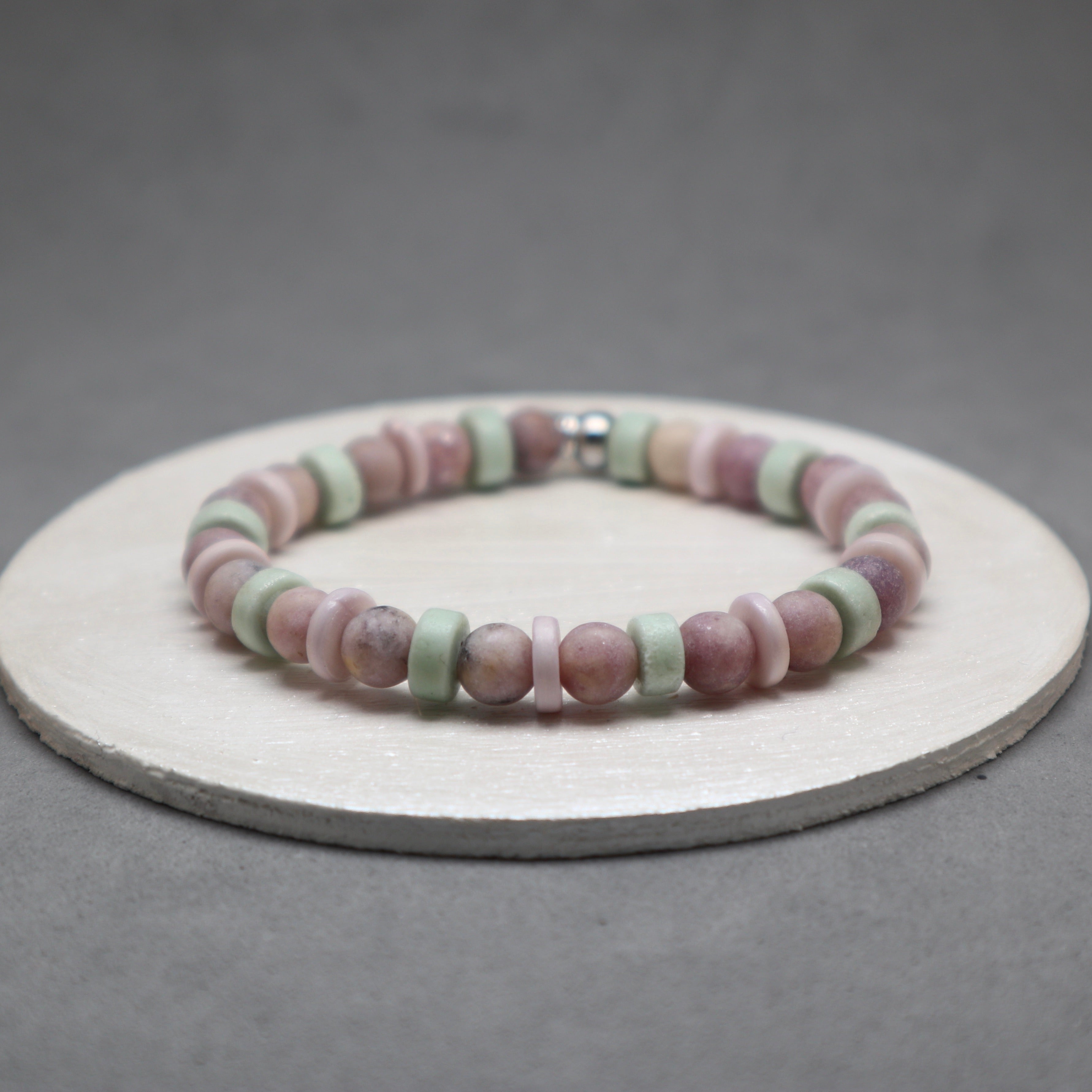 Multicolored beaded bracelet on a gray background,lepidolite, purple bone, mint bone heishi