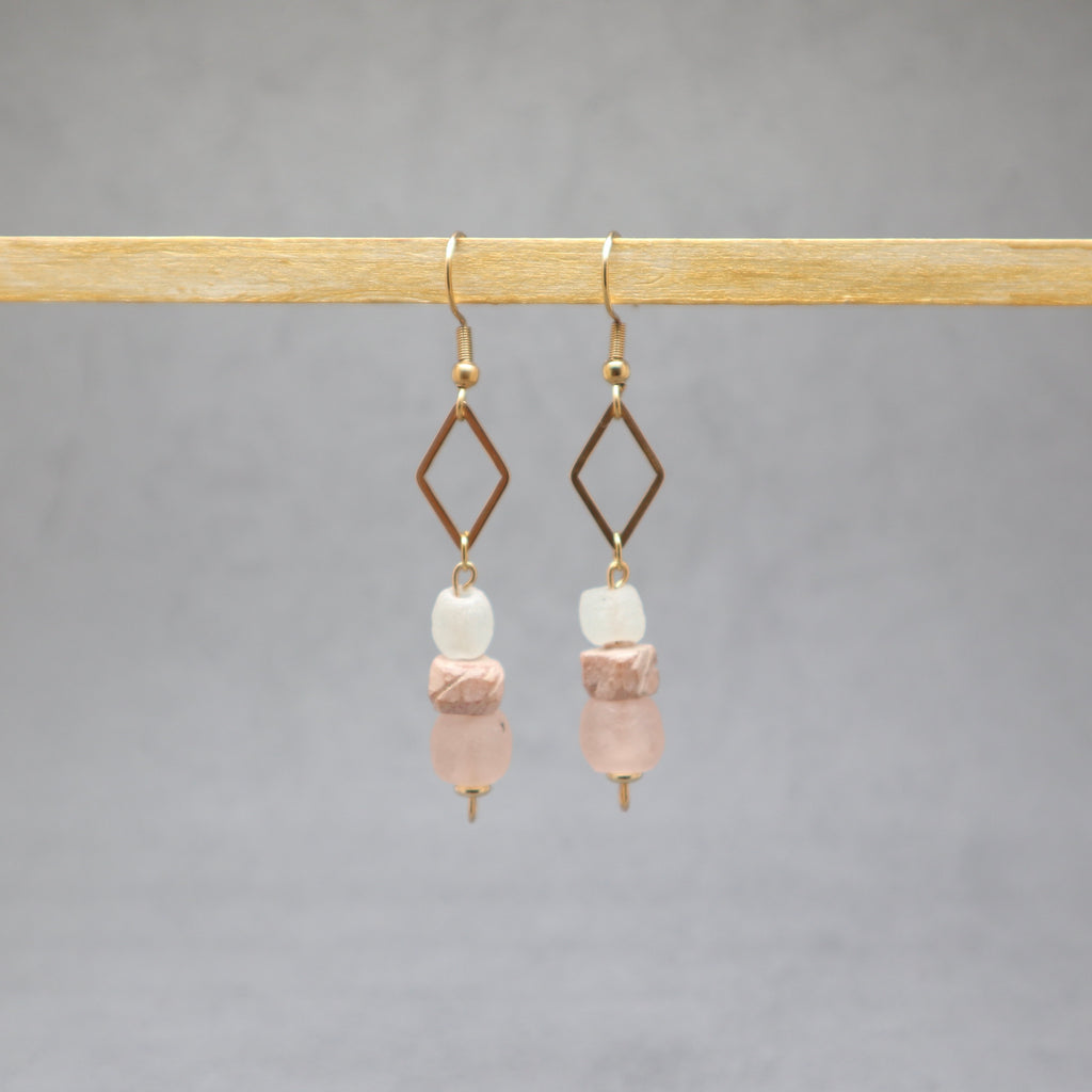 Pair of earrings with pink and white beads on a gray background, stainless steel, bone, recycled glass