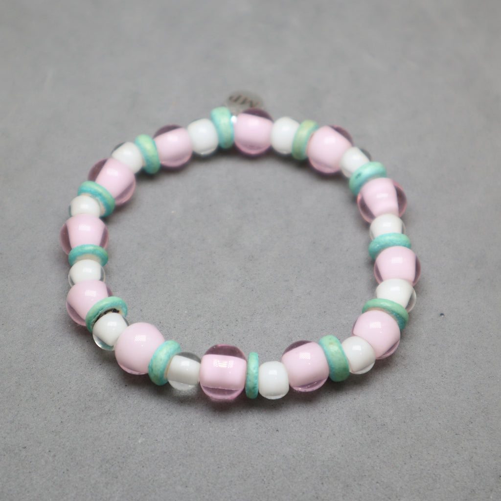 Beaded bracelet with pink, white, and green beads on a gray background