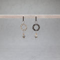 Pair of earrings with circular designs and beads hanging on a gray background, labradorite, stainless steel, heishi shell