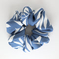 Blue and white patterned scrunchie on a light gray background