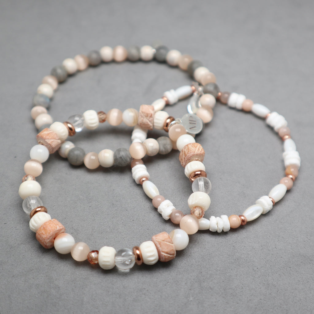 Set of beaded bracelets on a gray surface, bon, quartz, eye cat's beds, shell, moonstone, labradorite, ceramic, stainless steel