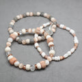 Set of beaded bracelets on a gray surface, bon, quartz, eye cat's beds, shell, moonstone, labradorite, ceramic, stainless steel