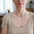 Person wearing a colorful beaded necklace indoors