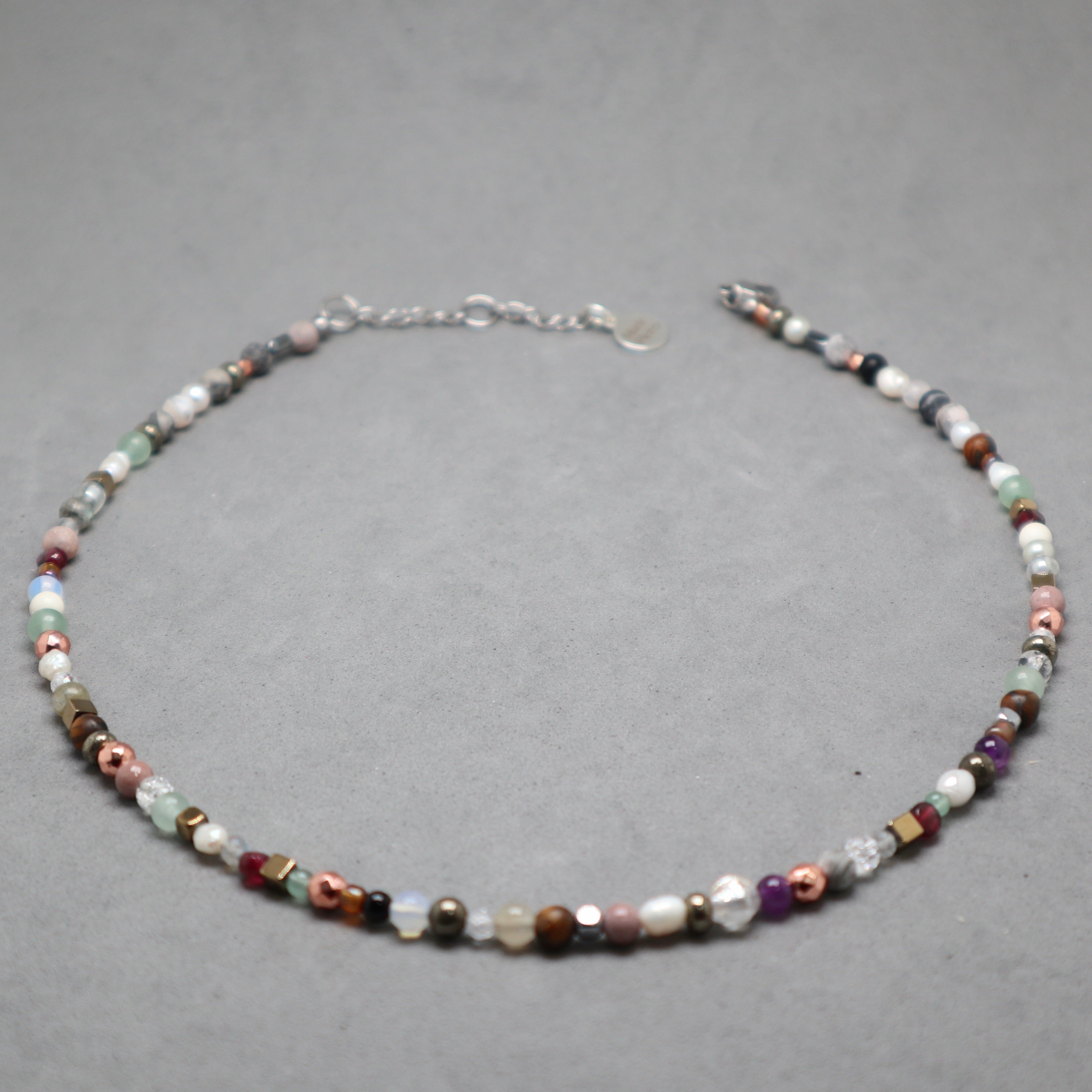 Multicolored beaded necklace on a gray background