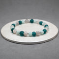 Beaded bracelet with green and white beads on a gray background