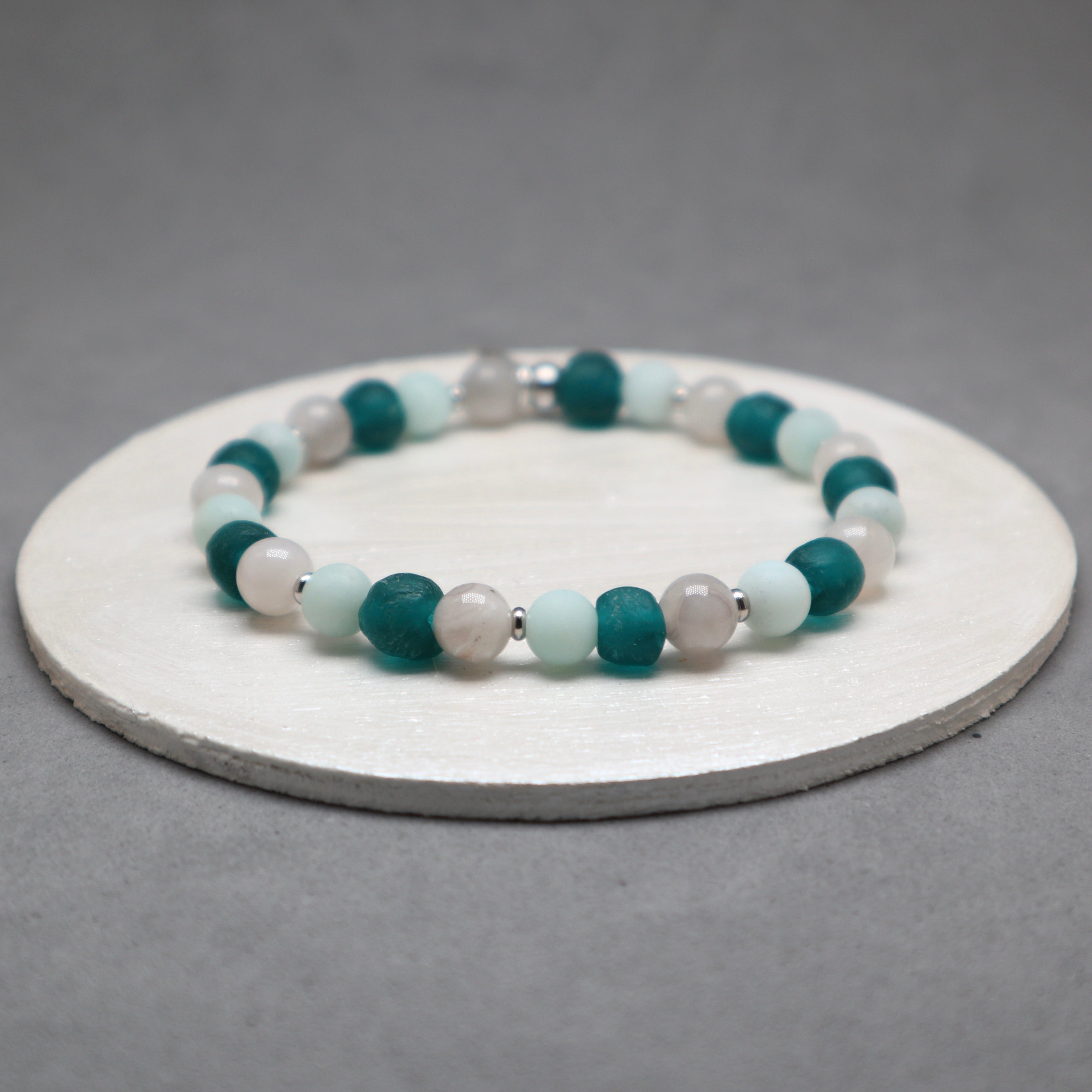 Beaded bracelet with green and white beads on a gray background