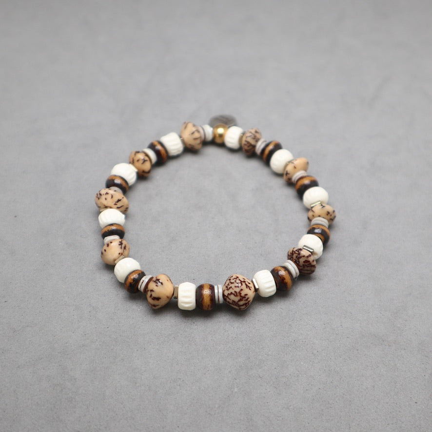 A beaded stretch bracelet featuring natural brown and white stones, displayed on a neutral gray background.