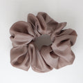 Taupe satin scrunchie on a light gray background