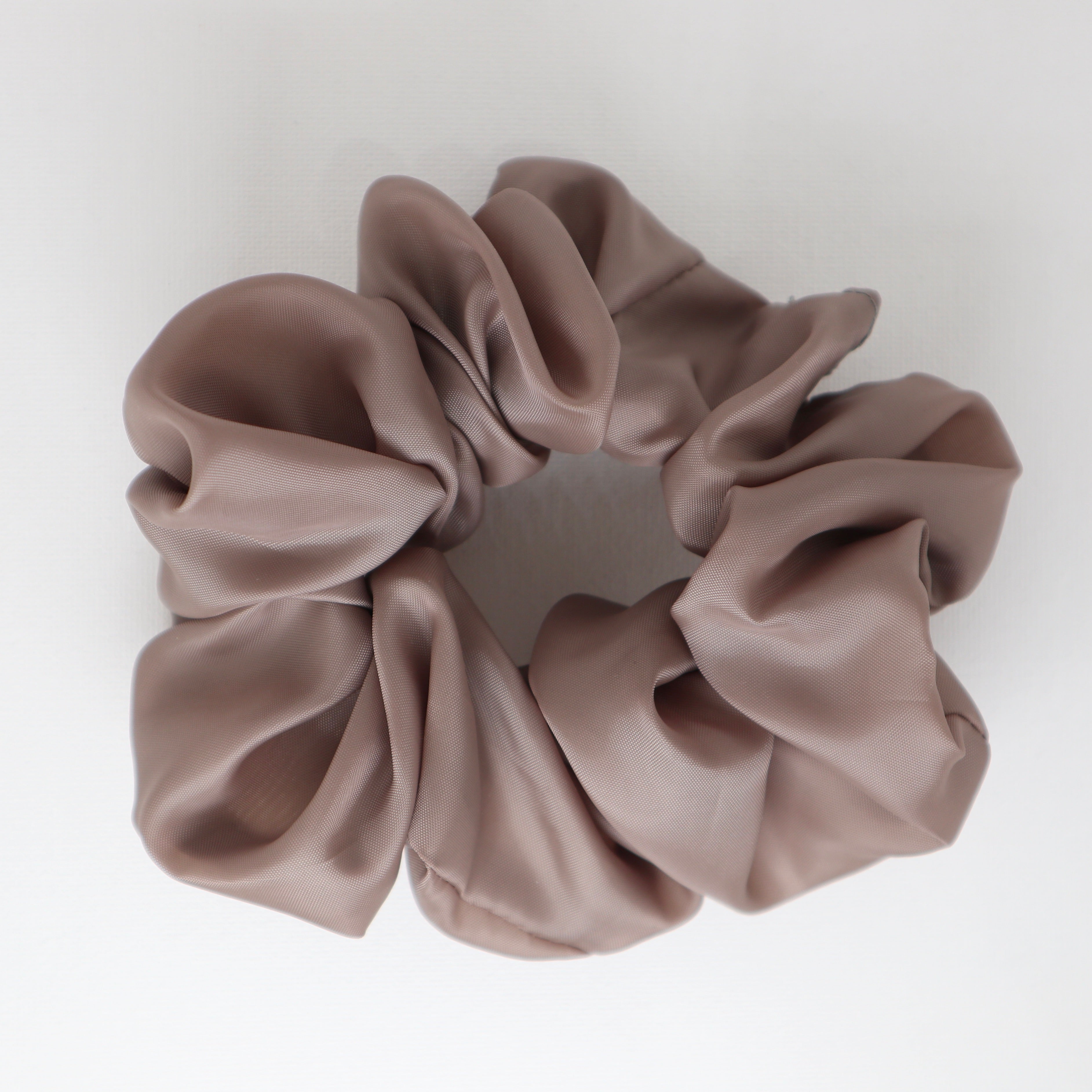 Taupe satin scrunchie on a light gray background